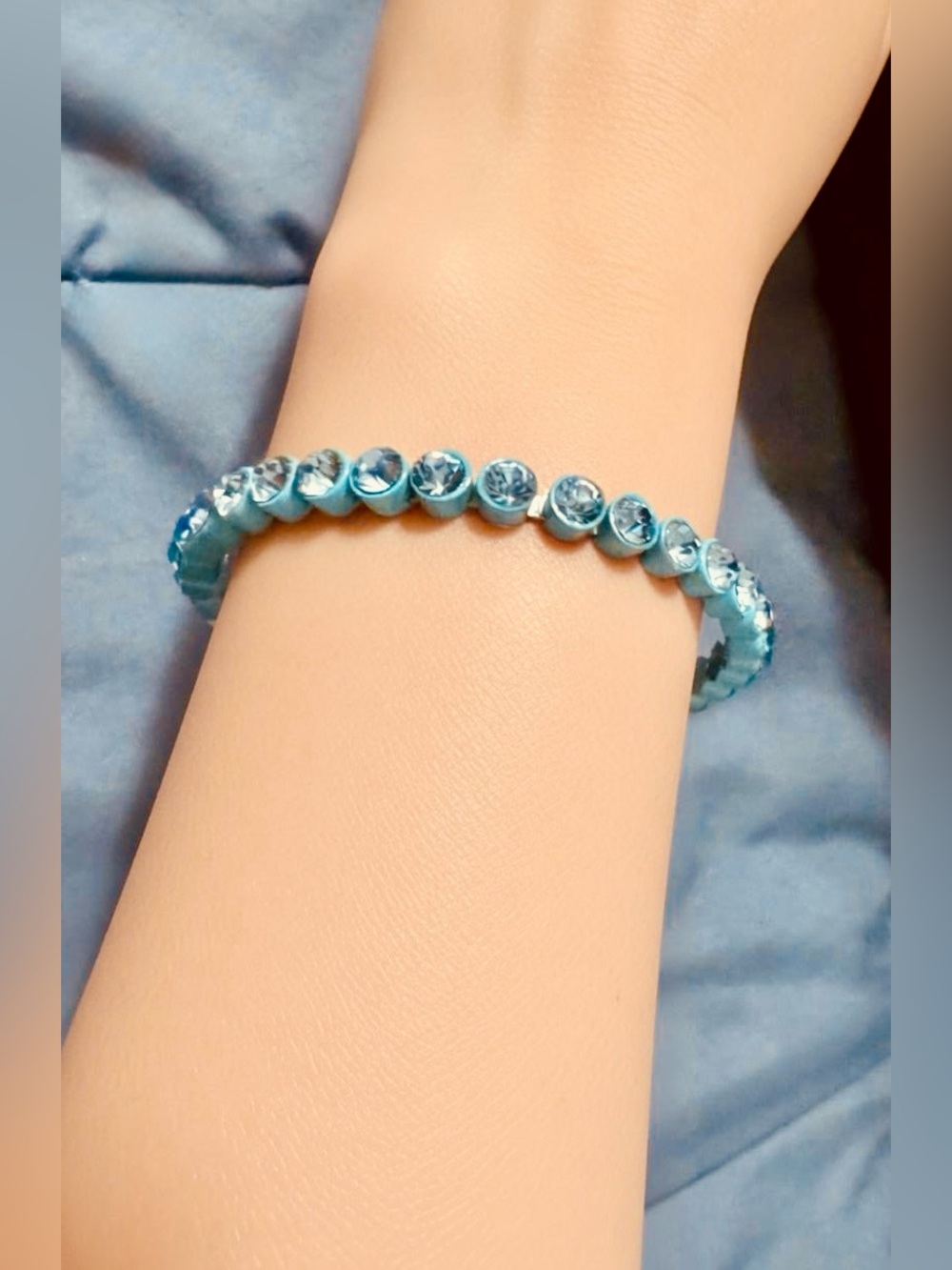 A bracelet featuring bright blue rhinestones set in a blue-colored metal frame